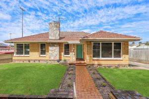 a house with a grass yard in front of it at Jack & Bias Cottage in Warrnambool