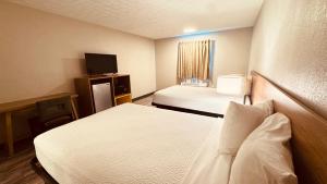 a hotel room with two beds and a television at Days Inn by Wyndham Amherst OH - Near Cleveland Cedar Point & Lake Erie in Amherst