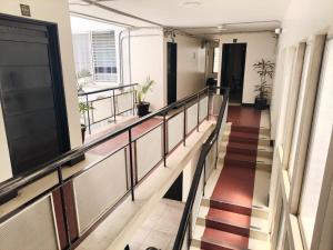 a hallway of an office building with stairs and plants at Hotel Villa Nueva Comfort in Medellín