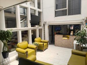 a patio with two yellow chairs and a bar at Hotel Villa Nueva Comfort in Medellín