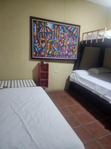 a room with two beds and a painting on the wall at tatay cabinas in La Cruz