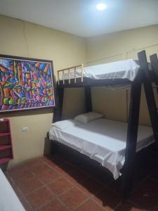 two bunk beds in a room with a painting on the wall at tatay cabinas in La Cruz