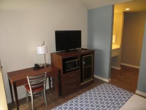a room with a desk with a television and a chair at Sterling Inn in Santa Clara