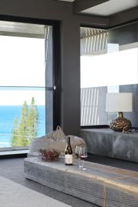 a room with a bed and two glasses of wine at Thirteen Bowman - Sunshine Beach, Ocean Views in Sunshine Beach