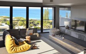 a living room with a couch and a view of the ocean at Thirteen Bowman - Sunshine Beach, Ocean Views in Sunshine Beach