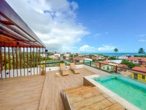a balcony with a pool and a view of the ocean at Hotel Kanto Do Chico Conceito in Icaraí