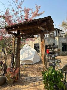 a wooden structure with a sign and a tent at สวนบ้านนอก SuanBaanNoak in Ban Phaet