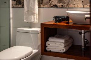 a bathroom with a toilet and a sink and towels at La Posada de Francisca in Pisac