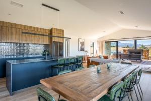 a kitchen and dining room with a wooden table and chairs at Carrickmore Lodge in Wanaka