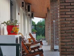 a porch with chairs and a vase on a brick wall at Departamentos Los Árboles in San Francisco del Monte de Oro