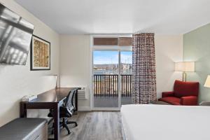 a room with a bed and a desk and a window at Marina Village Inn in Alameda