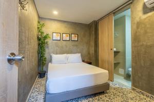 a bedroom with a bed and a walk in shower at Casa Presentacion Adaz Hotel in Santa Marta
