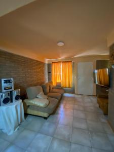 a living room with a couch and a tv at cabanas nahuel in Villa General Belgrano