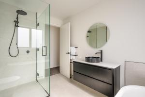 a bathroom with a shower and a sink and a mirror at Carrickmore Lodge in Wanaka +35 photos