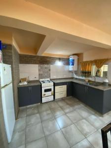 a kitchen with a white refrigerator and a stove at cabanas nahuel in Villa General Belgrano