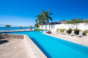 a swimming pool with chairs and the beach at Zantamar TH06B, oceanfront in Cruz de Huanacaxtle +26 photos
