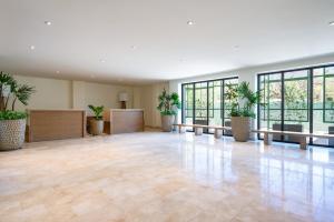 an empty lobby with potted plants and tables and windows at Zantamar TH06B, oceanfront in Cruz de Huanacaxtle