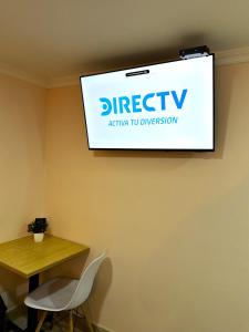 a projection screen on a wall with a table and chairs at KLEINN HOTEL BOGOTÁ in Bogotá