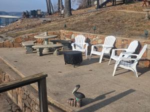 a goose standing in front of a group of chairs and a table at Shady Valley Lakefront Cottage in Sunrise Beach