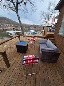 a deck with a couch and chairs and a table at Shady Valley Lakefront Cottage in Sunrise Beach +10 photos
