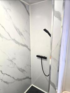 a bathroom with a shower with white marble walls at Red Lions Liverpool in Liverpool