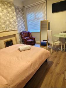 a bedroom with a bed and a table and a chair at Red Lions Liverpool in Liverpool
