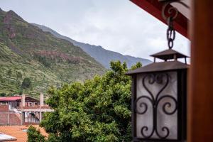 a lamp hanging from a building with mountains in the background at La Posada de Francisca in Pisac +61 photos