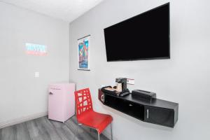 a living room with a red chair and a television at Royal Pagoda Motel Dodger Stadium in Los Angeles +17 photos