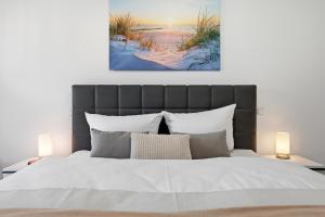 a bedroom with a large white bed with two lamps at Bernsteinquartier, Whg 01 03 in Kölpinsee
