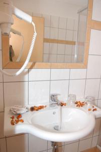 a bathroom with a sink and a mirror at Hotel-Pension Flora in Saalbach Hinterglemm