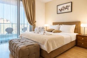 a bedroom with a large bed and a large window at Capitоl Suites & Apartments in Skopje