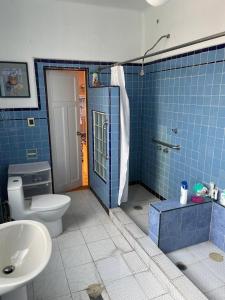 Ein blau gefliestes Badezimmer mit Toilette und Waschbecken in der Unterkunft Casa Luna in Mexiko-Stadt + 39 Fotos