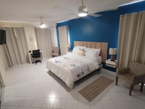 a bedroom with a bed and a blue wall at Sunny Bluu Villas in Meads Bay