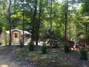a picnic table and bench in front of a cabin at Chalets Lanaudière - Yourtes in Rawdon +11 photos