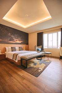 a bedroom with a large bed and a table at Horison Diana Timika in Timika