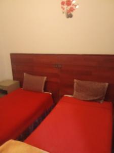 two beds sitting next to each other in a room at Hôtel des cedresazrou in Azrou