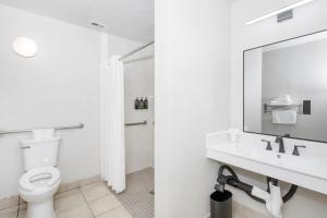 a bathroom with a toilet and a sink and a mirror at Royal Pagoda Motel Dodger Stadium in Los Angeles
