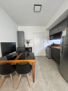 a kitchen with a desk with two chairs and a refrigerator at Loft Exclusivo - Maxplaza in Canoas