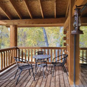 a table and chairs on a porch of a cabin at BuffaloPeaks Lodge in Buena Vista
