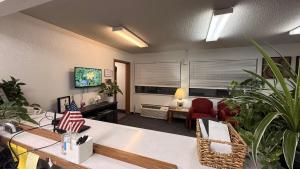 a living room with potted plants and a room with a table at clarion hometown inn in Clarion