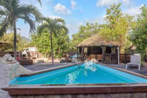 a swimming pool at a resort with a gazebo at Les Cottages Couleur Café in Cul de Sac