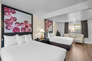 a hotel room with two beds and a chair at Rose Garden Inn - San Jose Airport in San Jose +10 photos