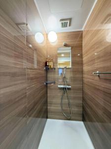 a bathroom with a shower with wooden walls at Ueno K in Tokyo +71 photos