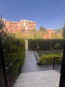 a walkway in a park with buildings in the background at Garden Apartment in Sheikh Zayed Private Entrance 24h Security in Sheikh Zayed