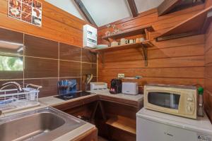 a small kitchen with a sink and a microwave at Les Cottages Couleur Café in Cul de Sac +44 photos