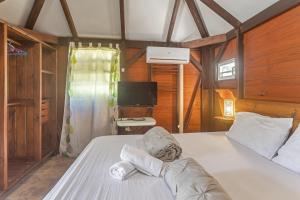 a bedroom with a large white bed with a desk at Les Cottages Couleur Café in Cul de Sac