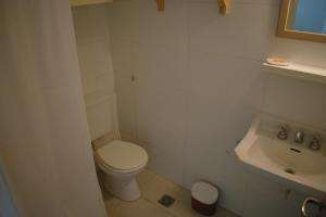 a white bathroom with a toilet and a sink at Destino Güemes Cozy Studio in Mar del Plata