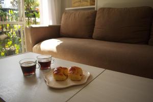two donuts on a plate on a table with two glasses of soda at Destino Güemes Cozy Studio in Mar del Plata