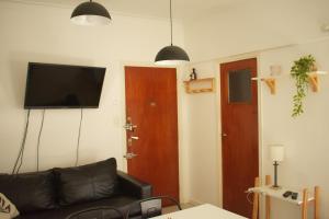 a living room with a couch and a flat screen tv at Destino Güemes Cozy Studio in Mar del Plata
