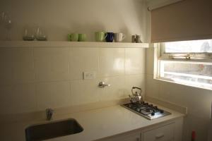 a kitchen with a sink and a stove and a window at Destino Güemes Cozy Studio in Mar del Plata +10 photos